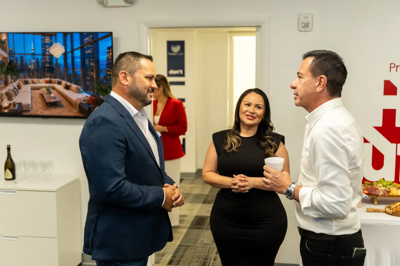 Tres asistentes conversando en el interior durante la inauguración de la sede Doral
