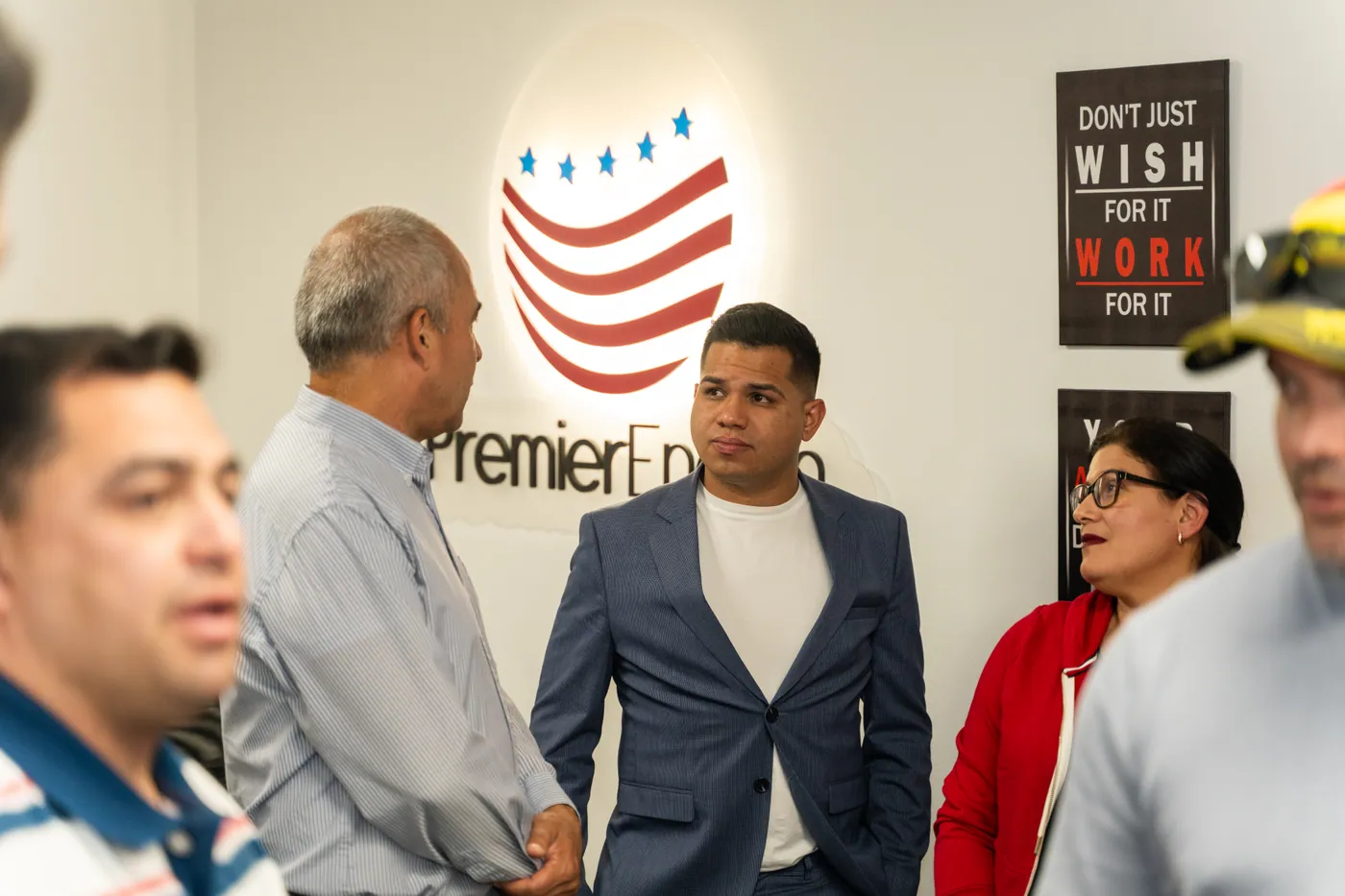 Asistentes reunidos junto al logotipo de Premier English durante la inauguración
